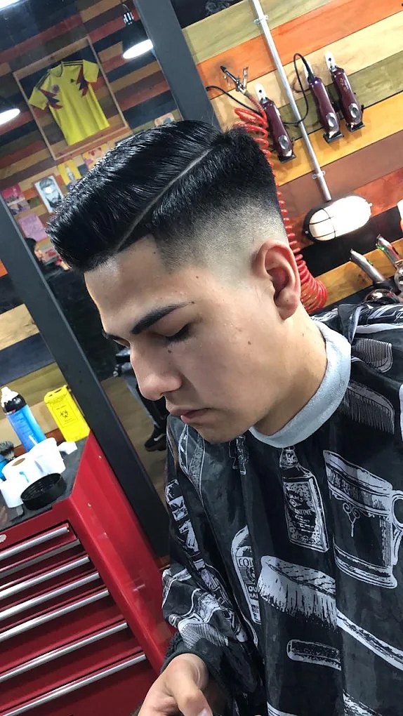 Corte terminado: pompadour con raya marcada y degradado a los lados