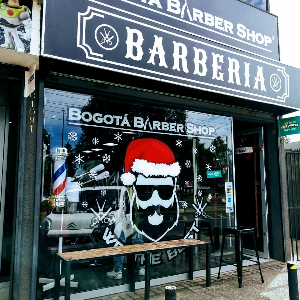 Fachada de Bogotá Barber Shop de día: el letrero negro que dice BARBERIA y la vitrina con el logo