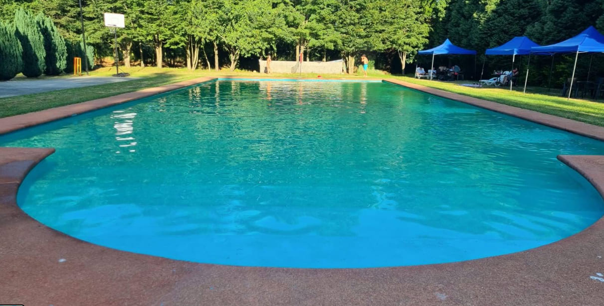 Piscina de Cabañas Puerta del Sol rodeada de bosque, en Loncoche