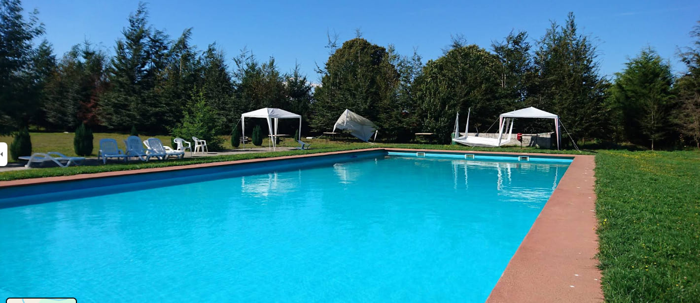 Piscina con toldos y reposeras en Cabañas Puerta del Sol