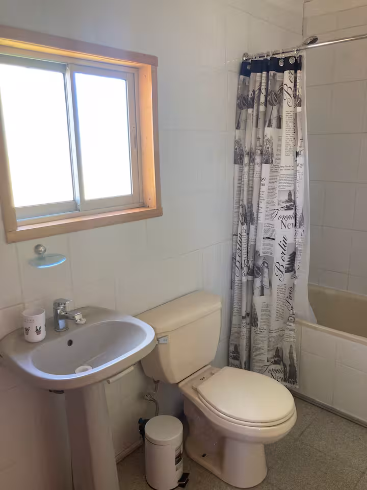 Baño con ducha, lavamanos y ventana