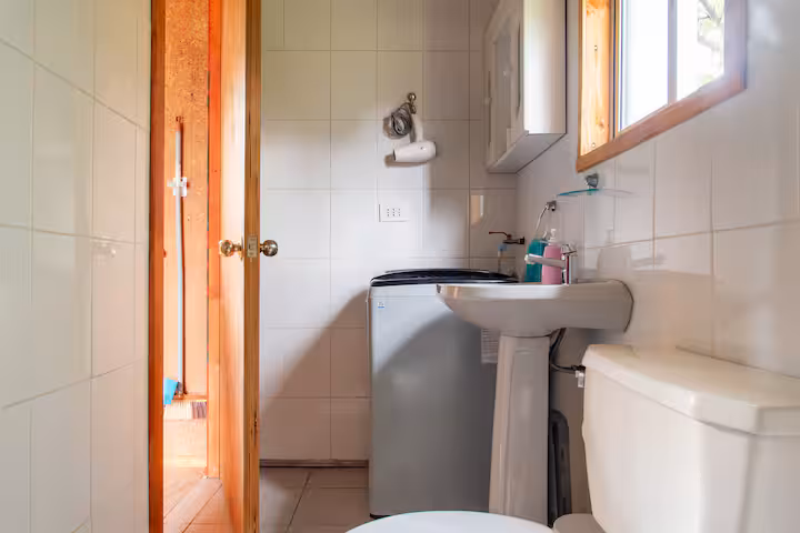 Baño de la cabaña con lavamanos y puerta de madera