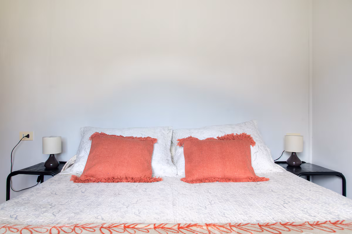 Dormitorio matrimonial con dos veladores y lámparas