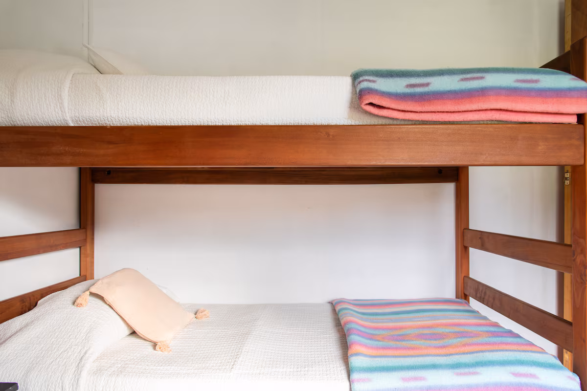 Literas con ropa de cama doblada sobre el colchón