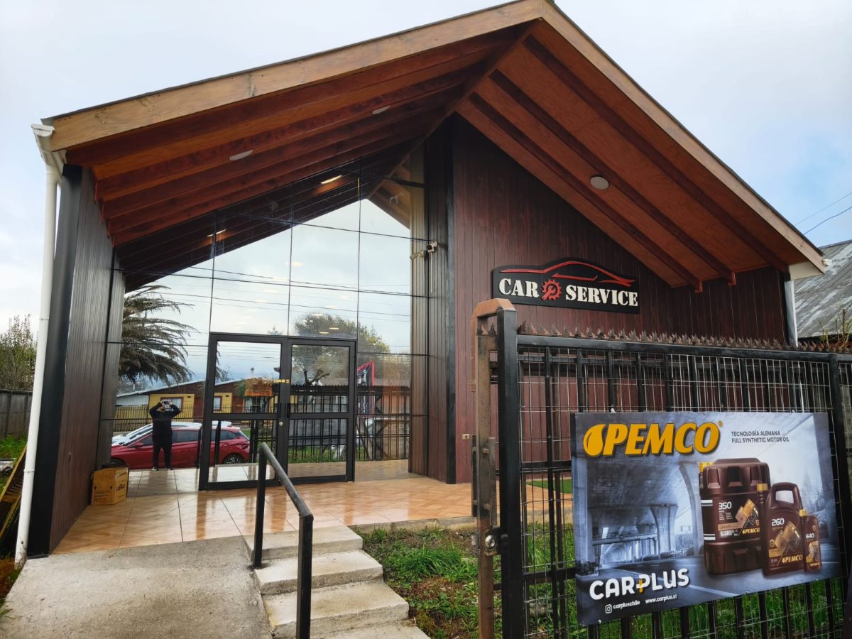 Fachada de Car Service en Barros Arana 152: revestimiento de madera, vitrina de vidrio y letrero iluminado