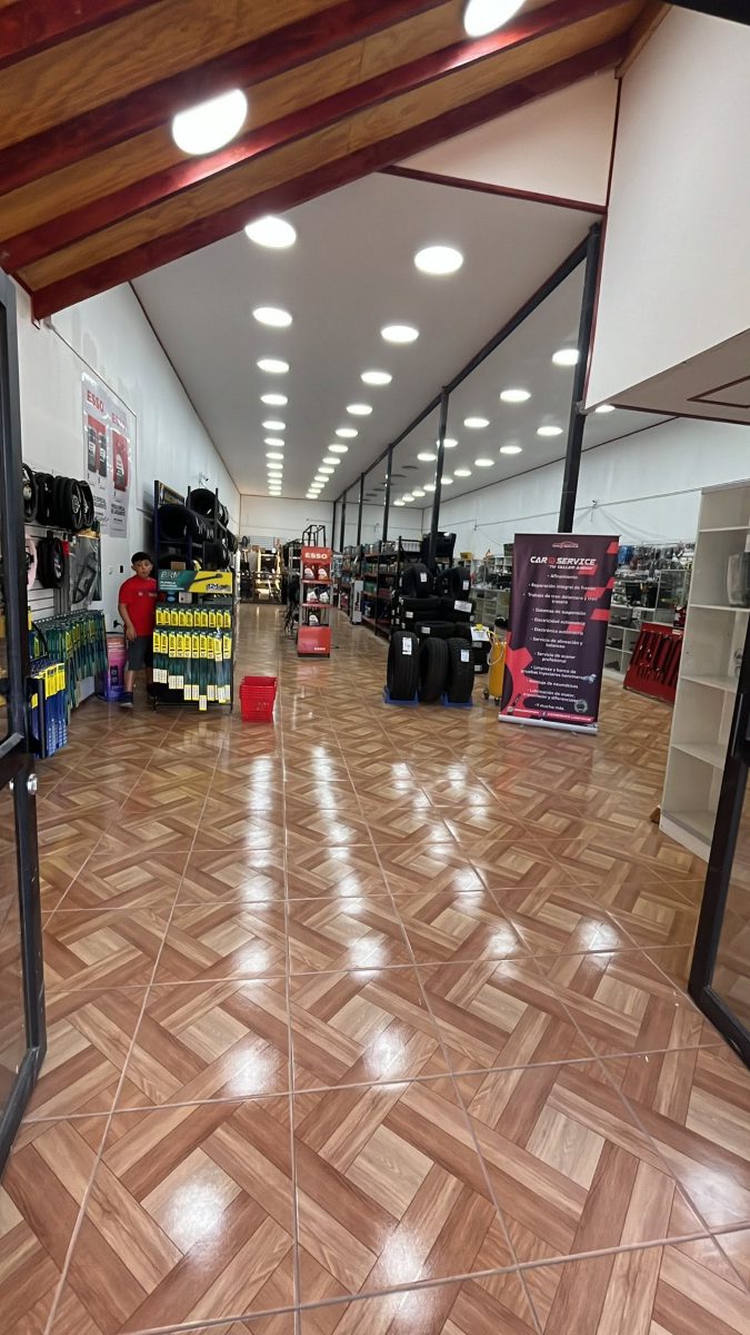 Salón de ventas de Car Service: estanterías con neumáticos, aceites y accesorios