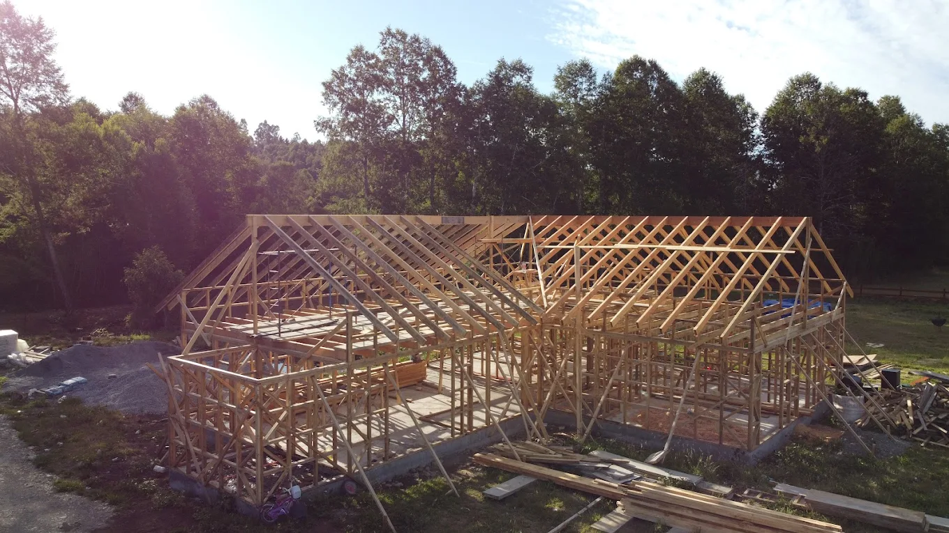 Estructura de cerchas de madera de un galpón grande en construcción, todavía sin cubierta.