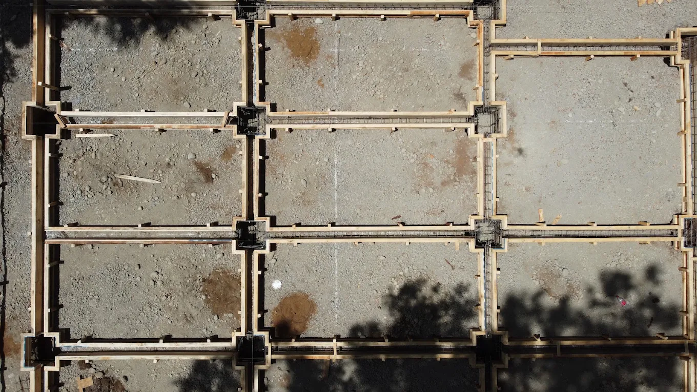 Muro de hormigón con moldaje metálico modular todavía puesto, visto de frente.