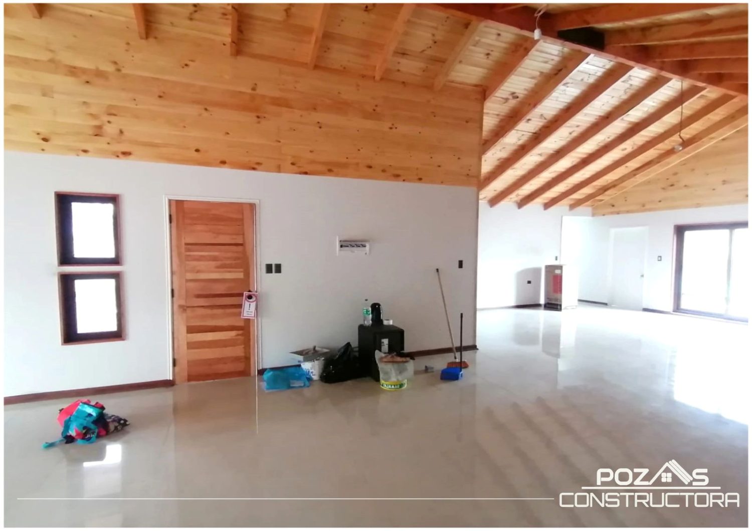 Interior amplio con el cielo de madera a la vista y las vigas descubiertas.