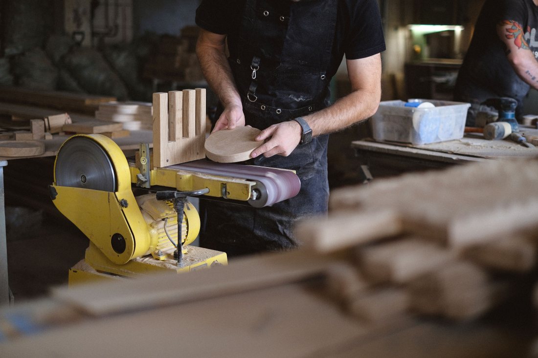 Lijadora trabajando una pieza de madera en el taller.