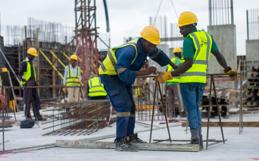 Trabajadores con casco revisando enfierradura en una obra.