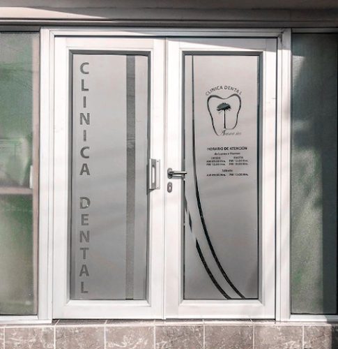 Puerta de vidrio esmerilado con «Clínica Dental» impreso en vertical y el horario de atención.