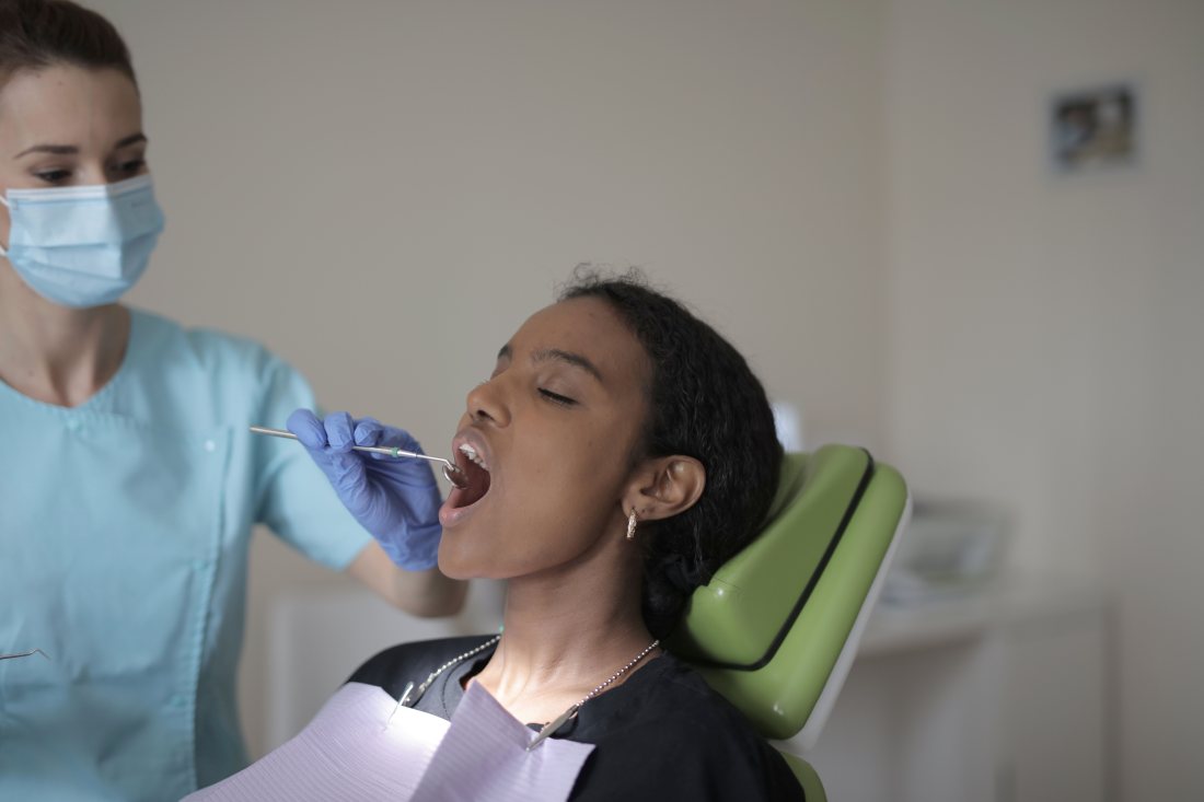 Atención odontológica en el sillón, con instrumental.