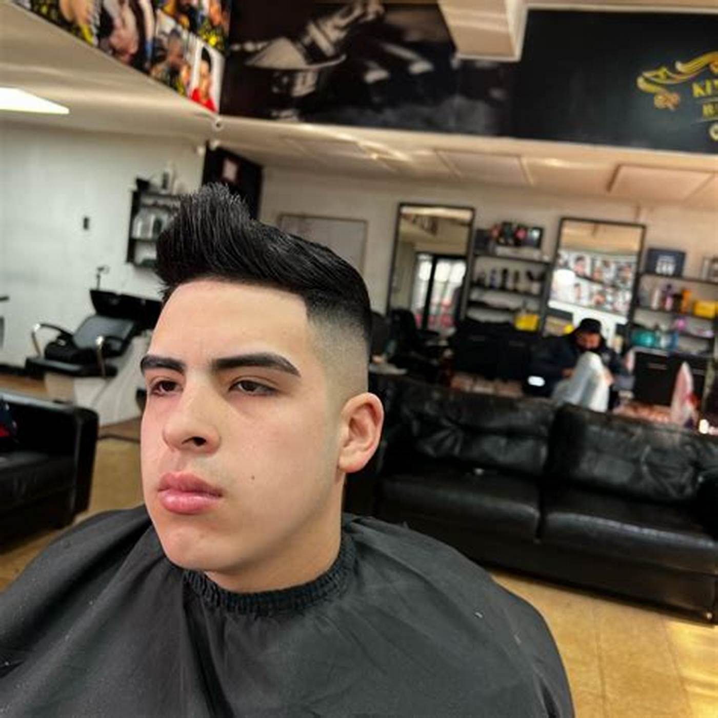 Cliente en el sillón con el corte recién terminado, con el salón de fondo.