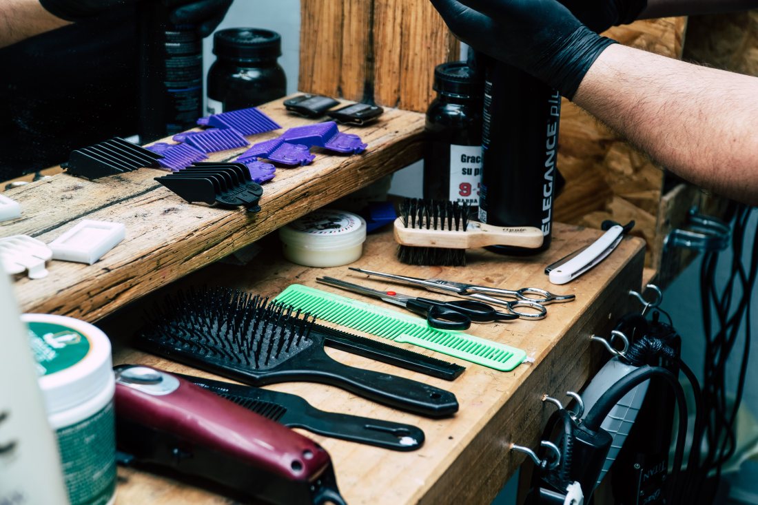 Tijeras, peines y productos sobre el mesón de la barbería.