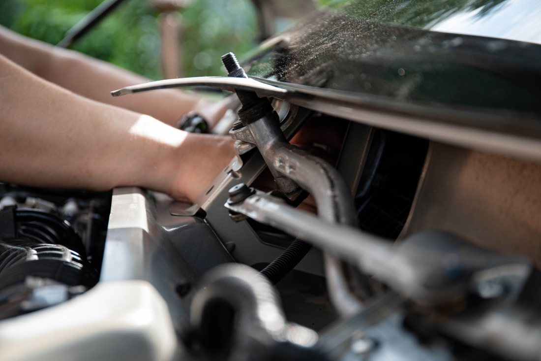Manos trabajando con herramienta sobre el motor.