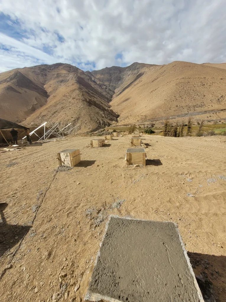 Poyos de hormigón y radier en un terreno en pendiente, listos para recibir una estructura.
