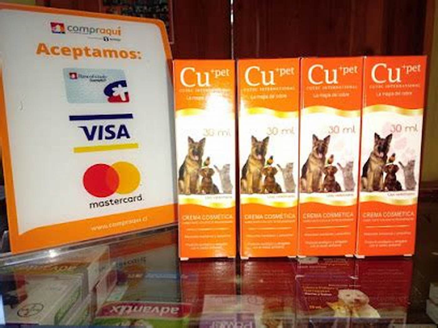 Mostrador de la clínica con los medios de pago aceptados y productos veterinarios en la vitrina.